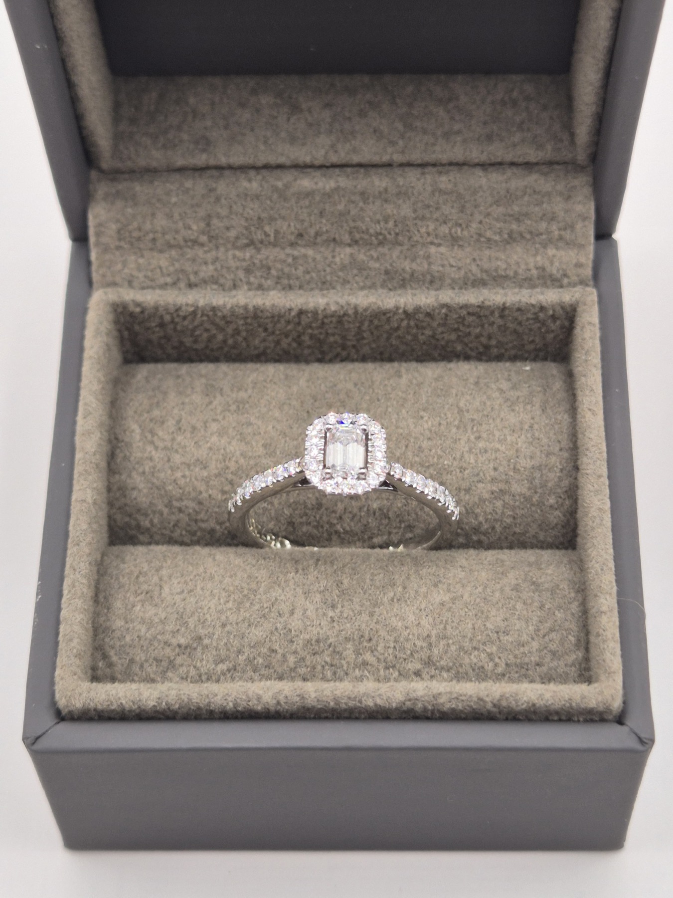Emerald-cut diamond with a halo in white gold